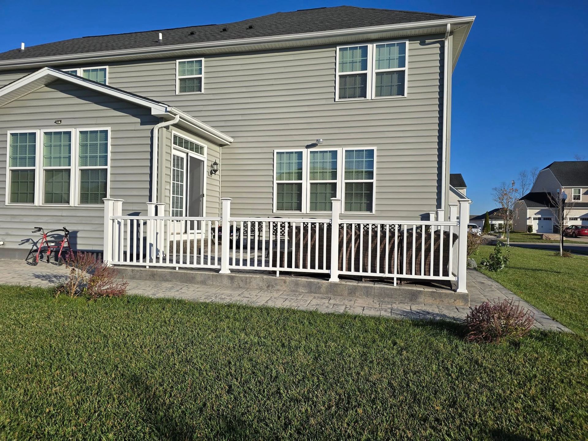 A wooden deck with a fence and trees in the background