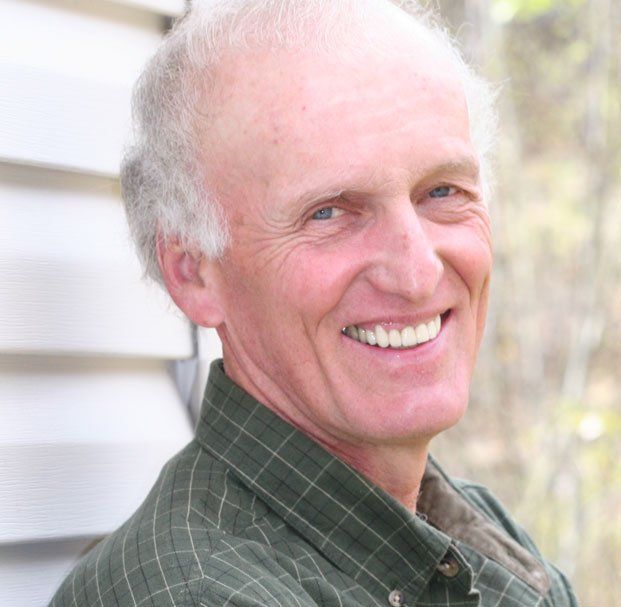 elder man with side part hair smiling