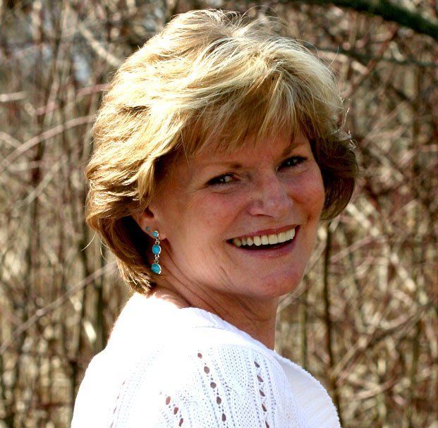 short hair woman with blue earrings smiling