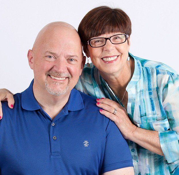 no hair elder man and short hair woman smiling