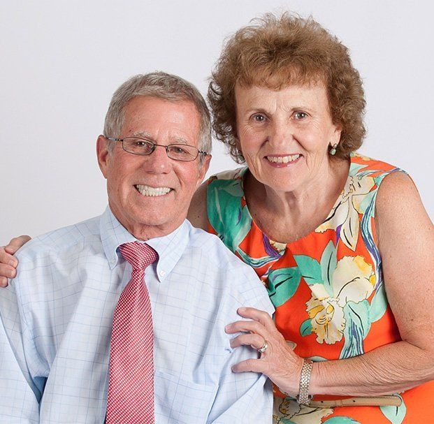 elder man with glasses and elder woman smiling