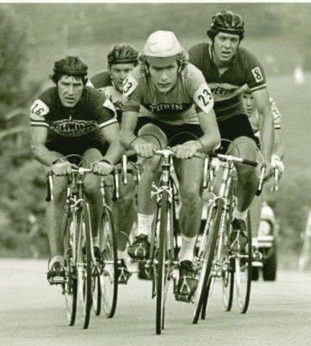 A group of men are riding bicycles down a road and one of them has the number 22 on his shirt