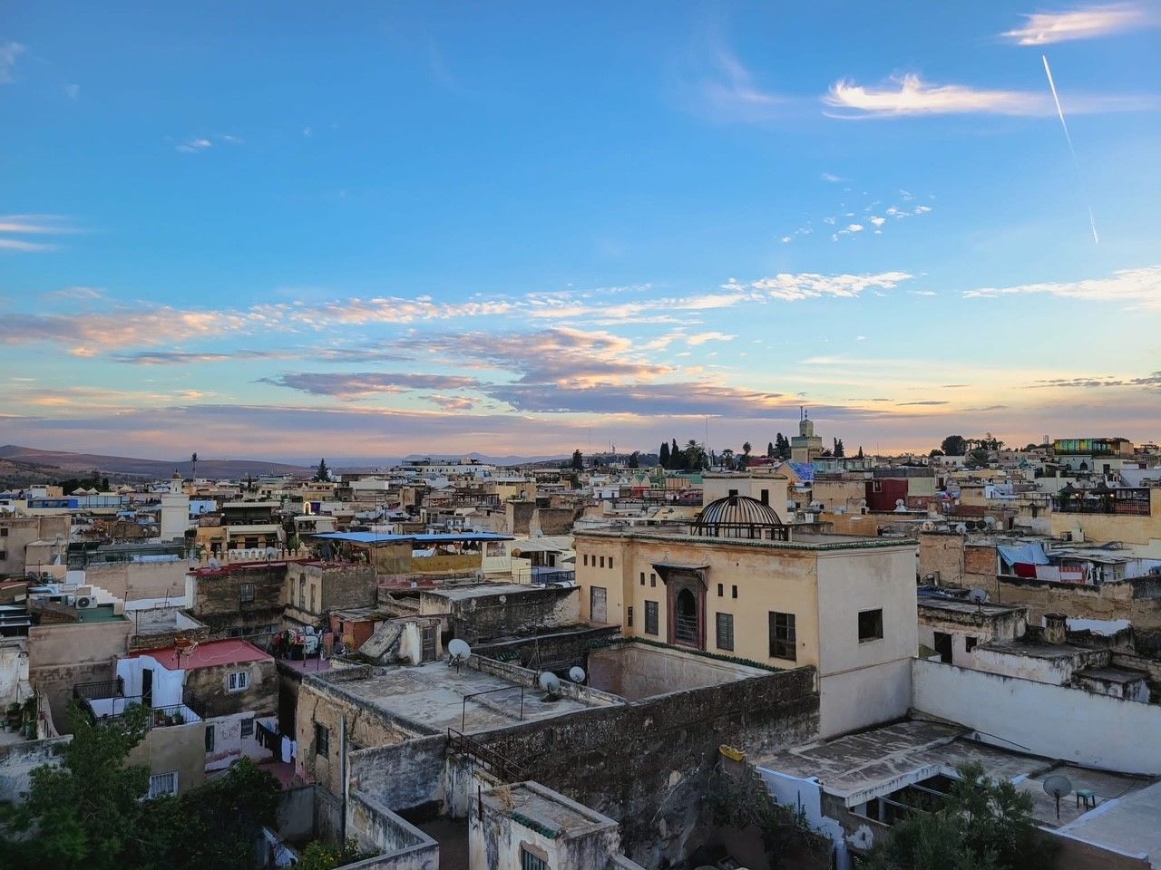 An aerial view of a city at sunset with a blue sky and clouds.