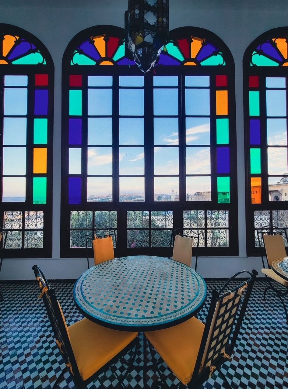A table and chairs in front of stained glass windows