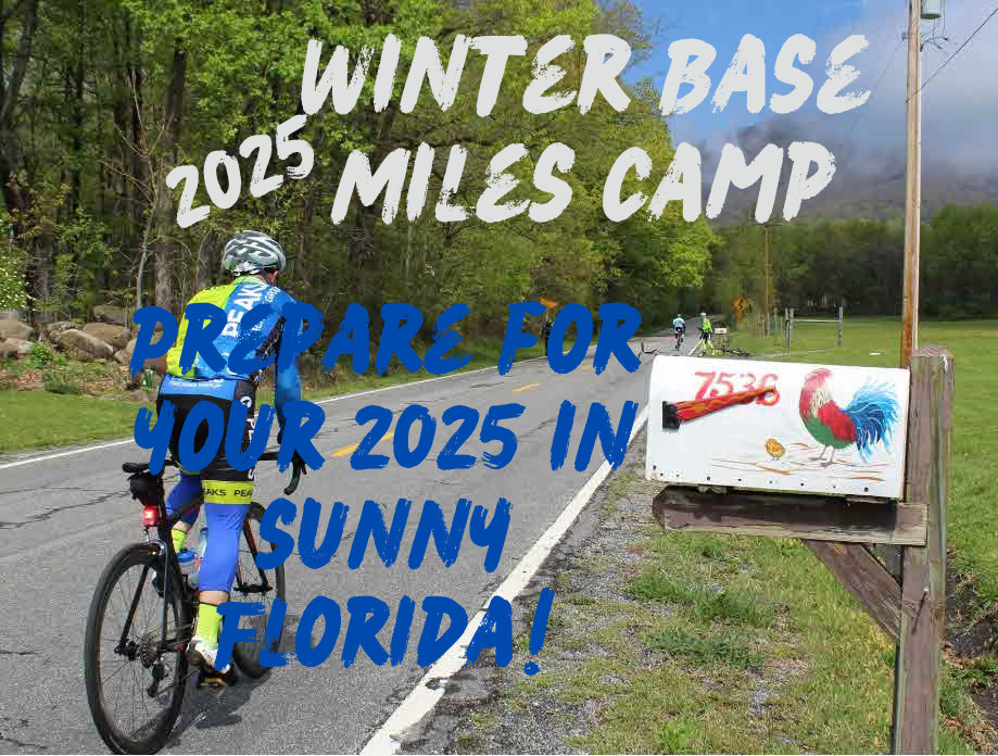 A person riding a bike down a road with a sign that says winter base 2025 miles camp