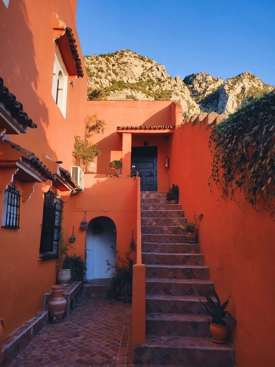 A set of stairs leading up to a building with a mountain in the background.
