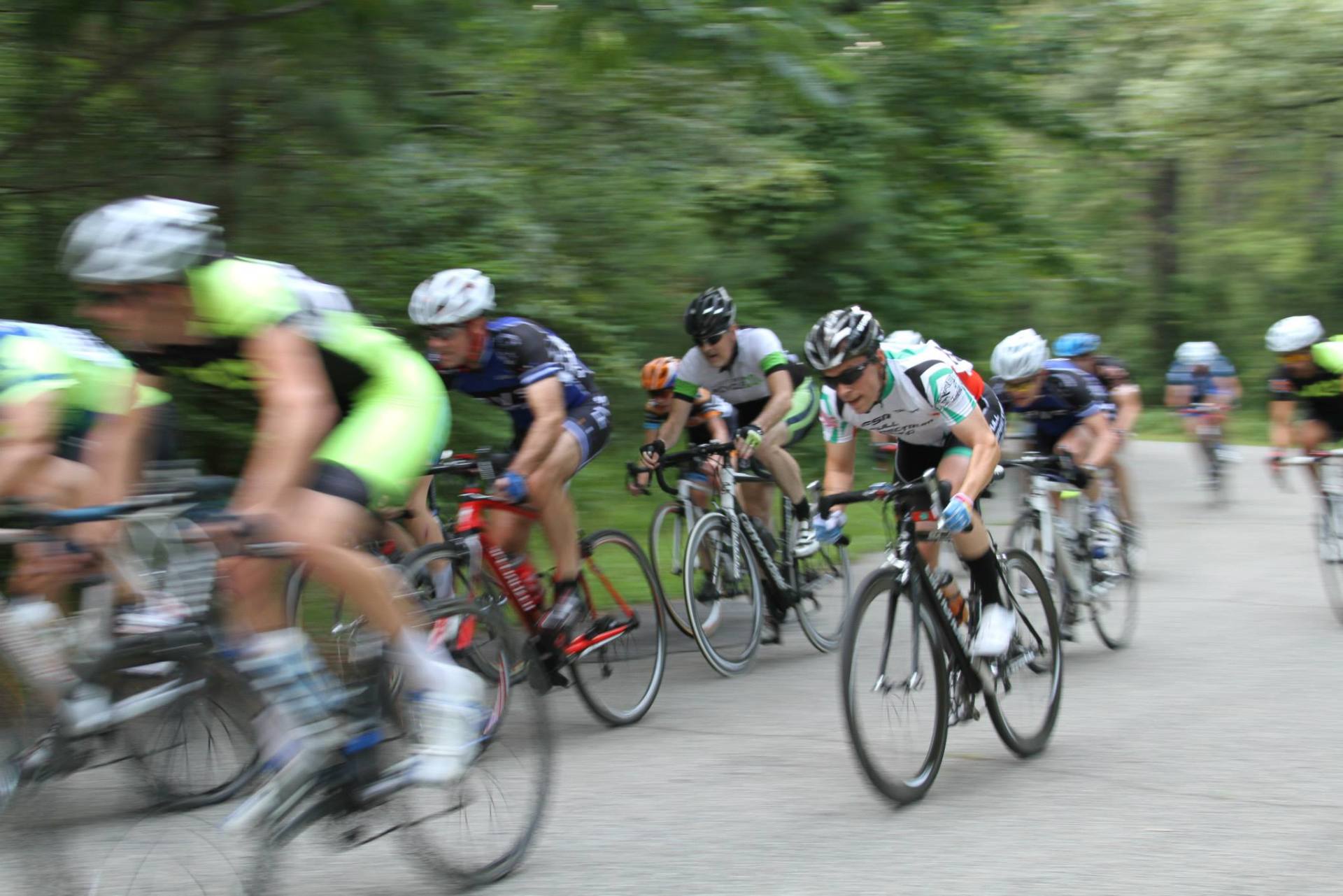 A group of cyclists are riding down a road.