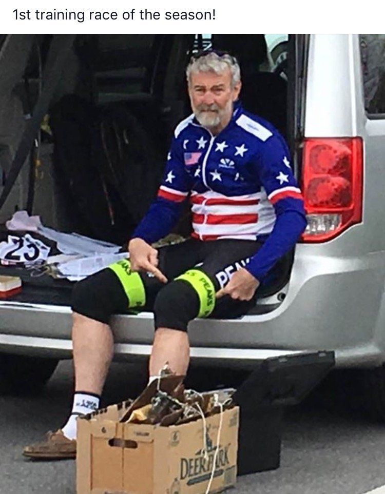 A man in an american flag shirt is sitting in the back of a car