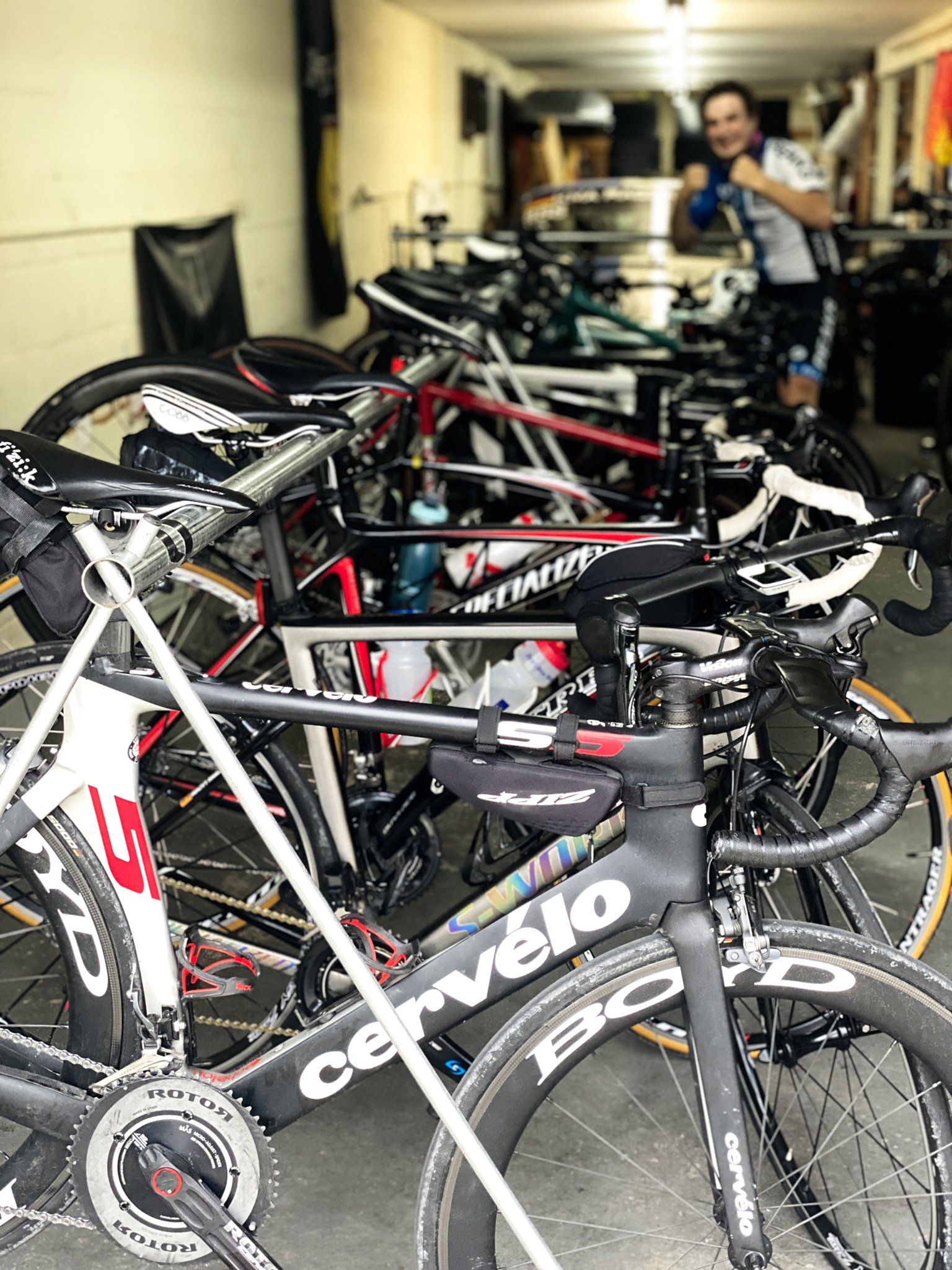 A row of bicycles are parked in a garage.
