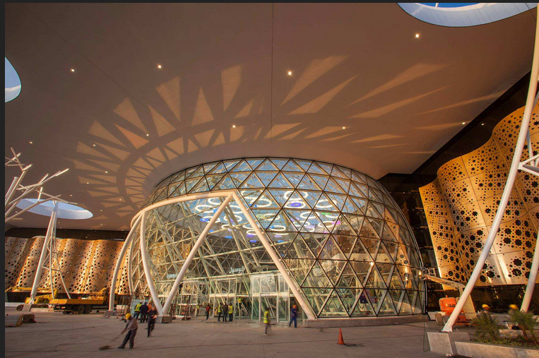 A large glass building with a circular design on the ceiling