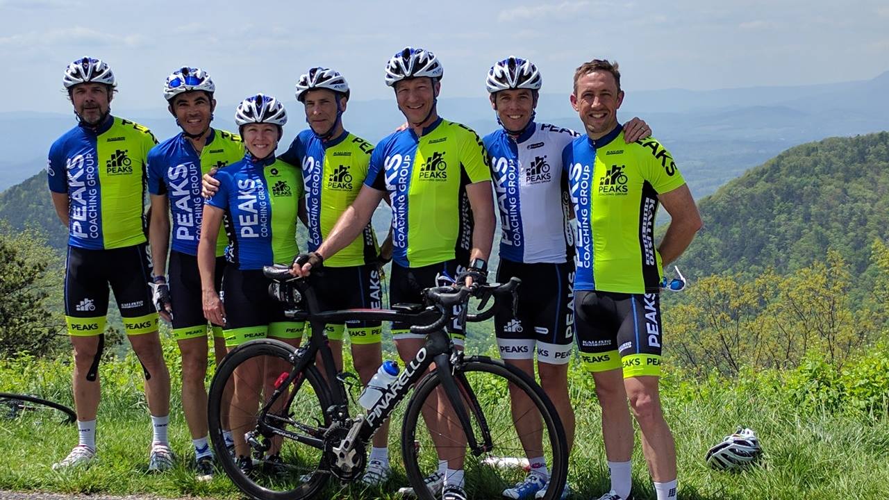 A group of cyclists are posing for a picture with their bikes