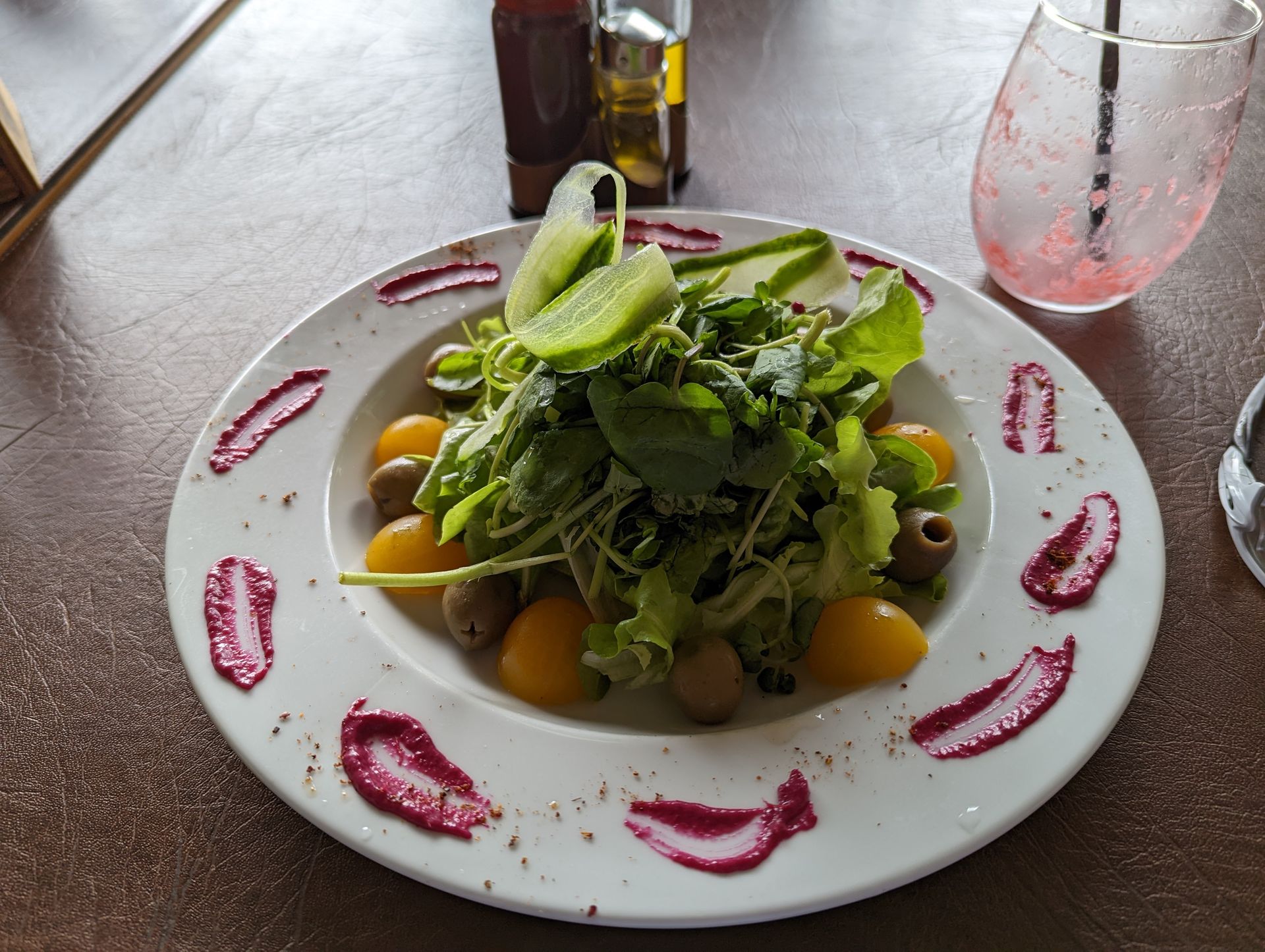 A salad with tomatoes and olives on a white plate