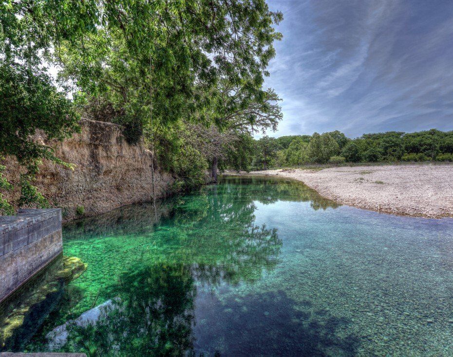 A large body of water surrounded by trees and rocks.