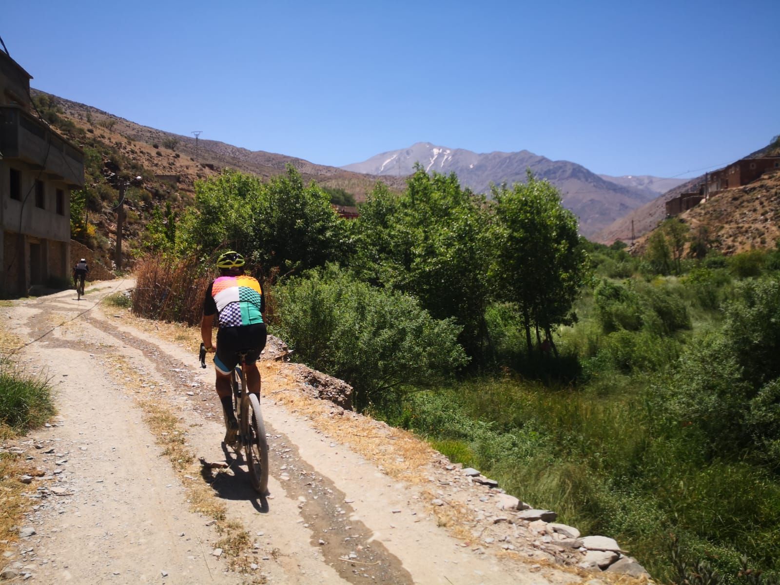 A person is riding a bike down a dirt road.