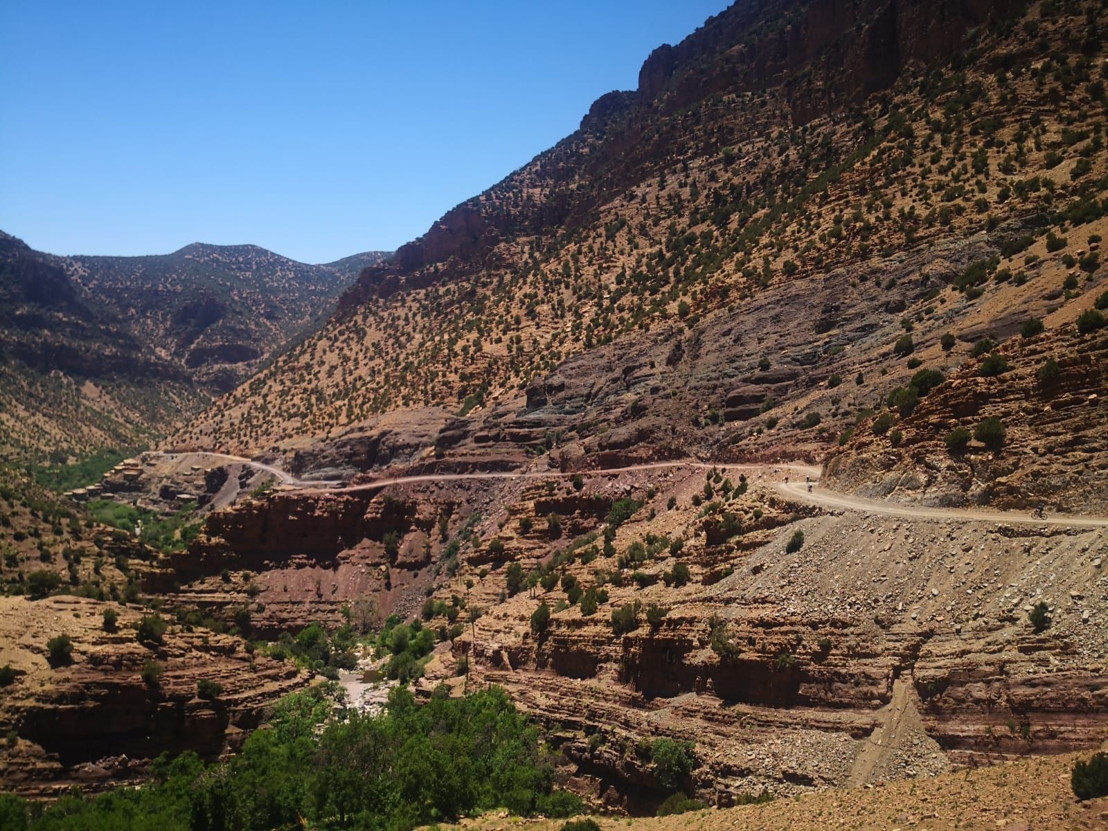 A road going through a valley with mountains in the background