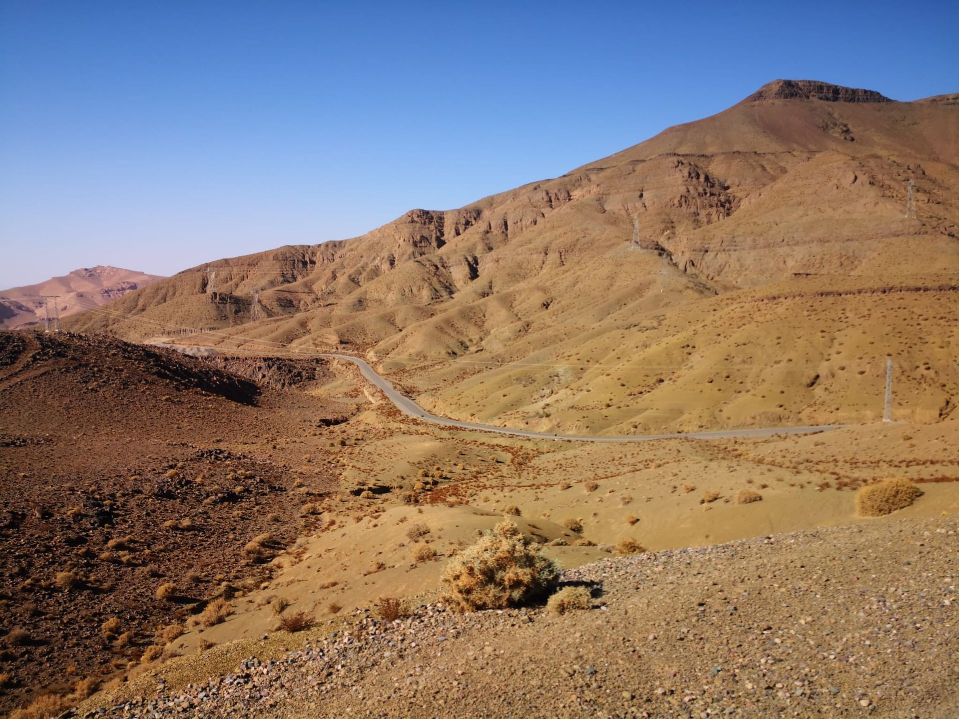 A desert landscape with mountains in the background and a road in the foreground