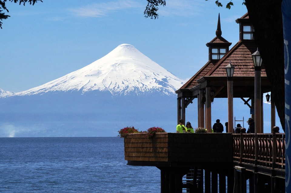 A pier with a mountain in the background and a gazebo in the foreground