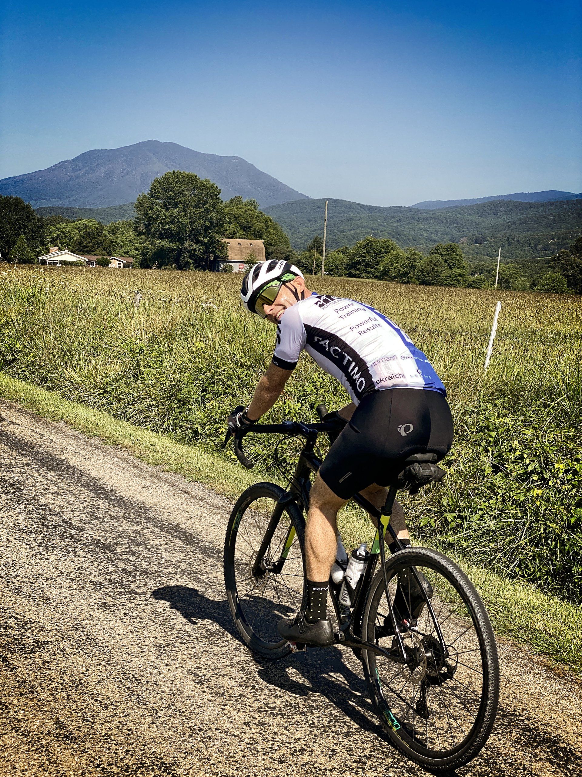 A man is riding a bike down a dirt road.