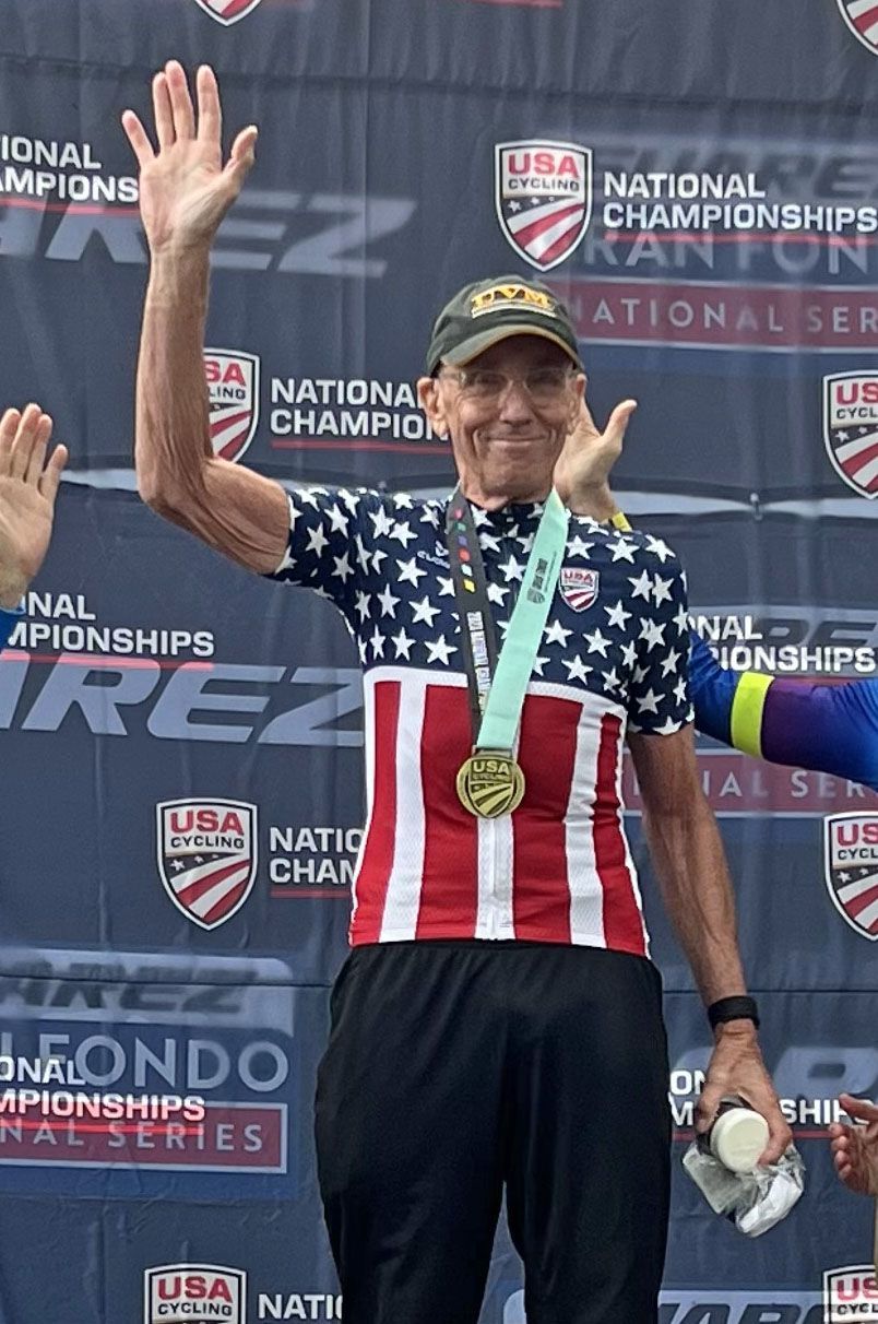 A man wearing an american flag shirt is standing on a podium.
