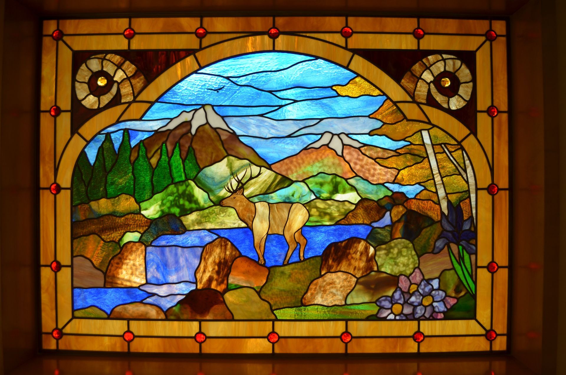 A stained glass window with flowers and leaves on it
