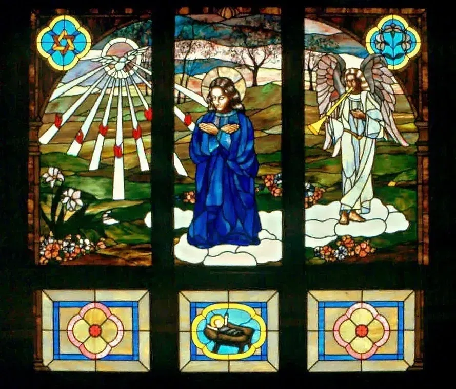 A stained glass window with grapes and wheat on it
