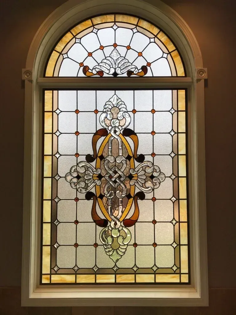 A large wooden door with a stained glass window