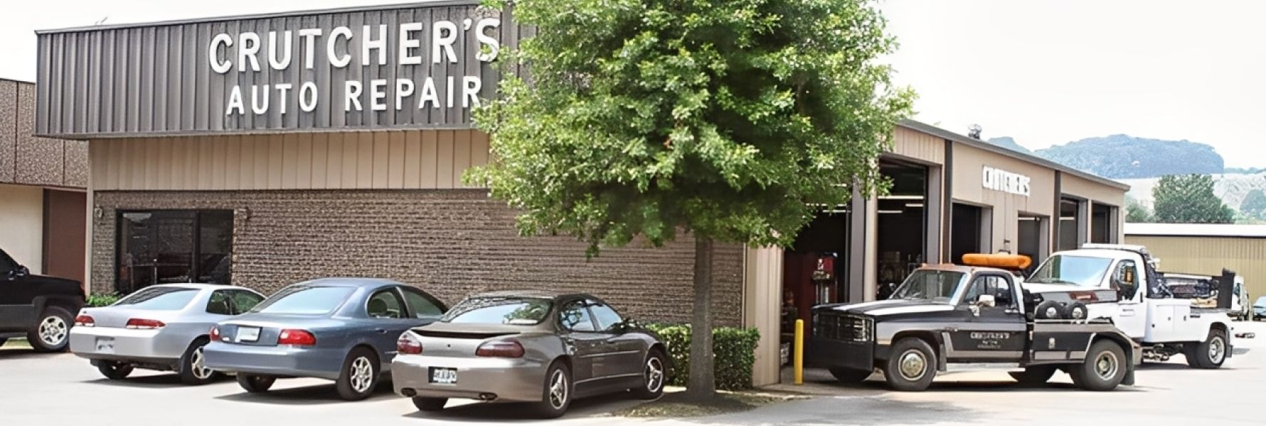 Crutcher's Auto Repair building with several cars parked outside and tow trucks visible in the garage.| Crutcher's Auto Repair