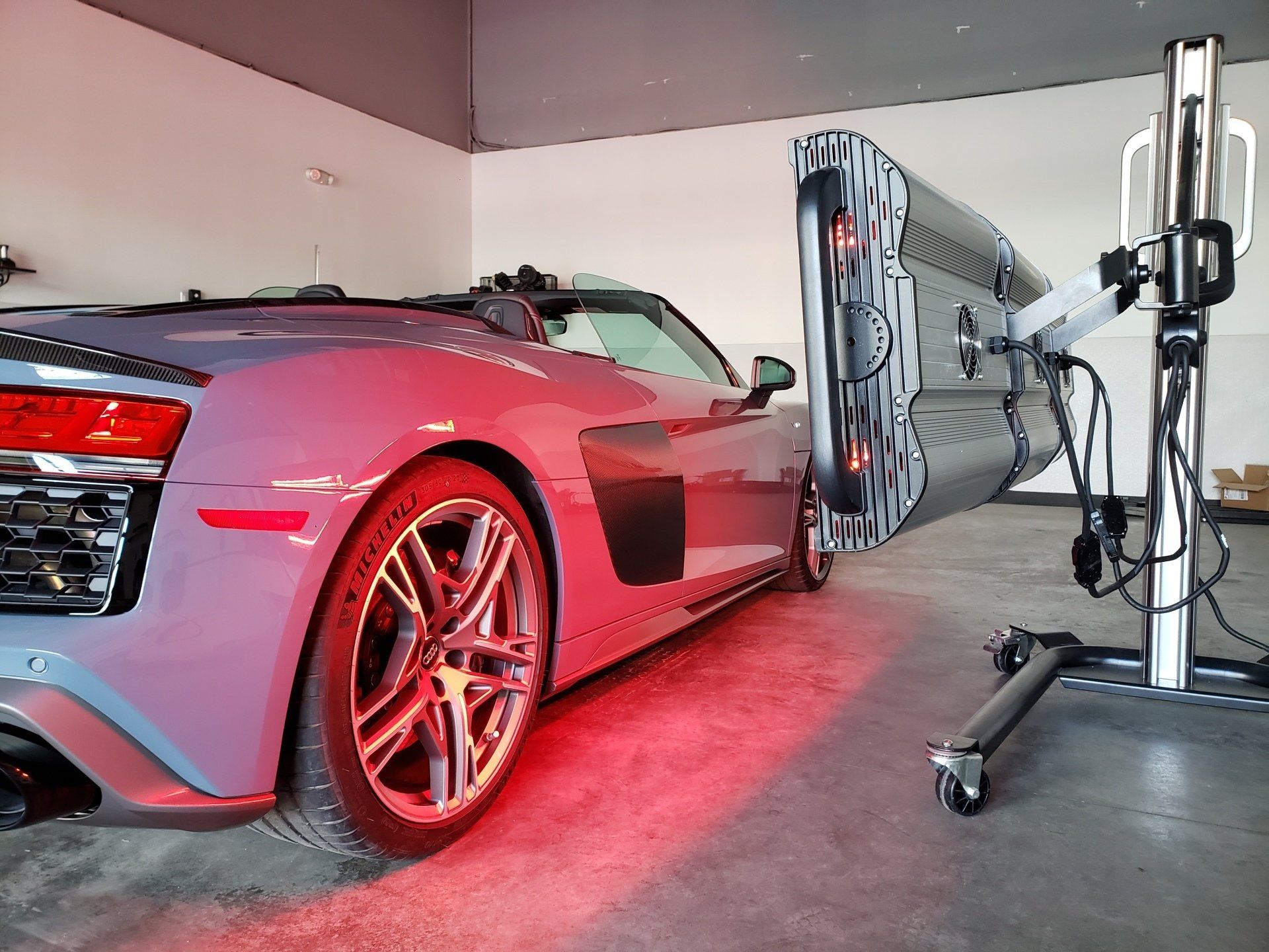 A car is sitting in a garage next to a red light.
