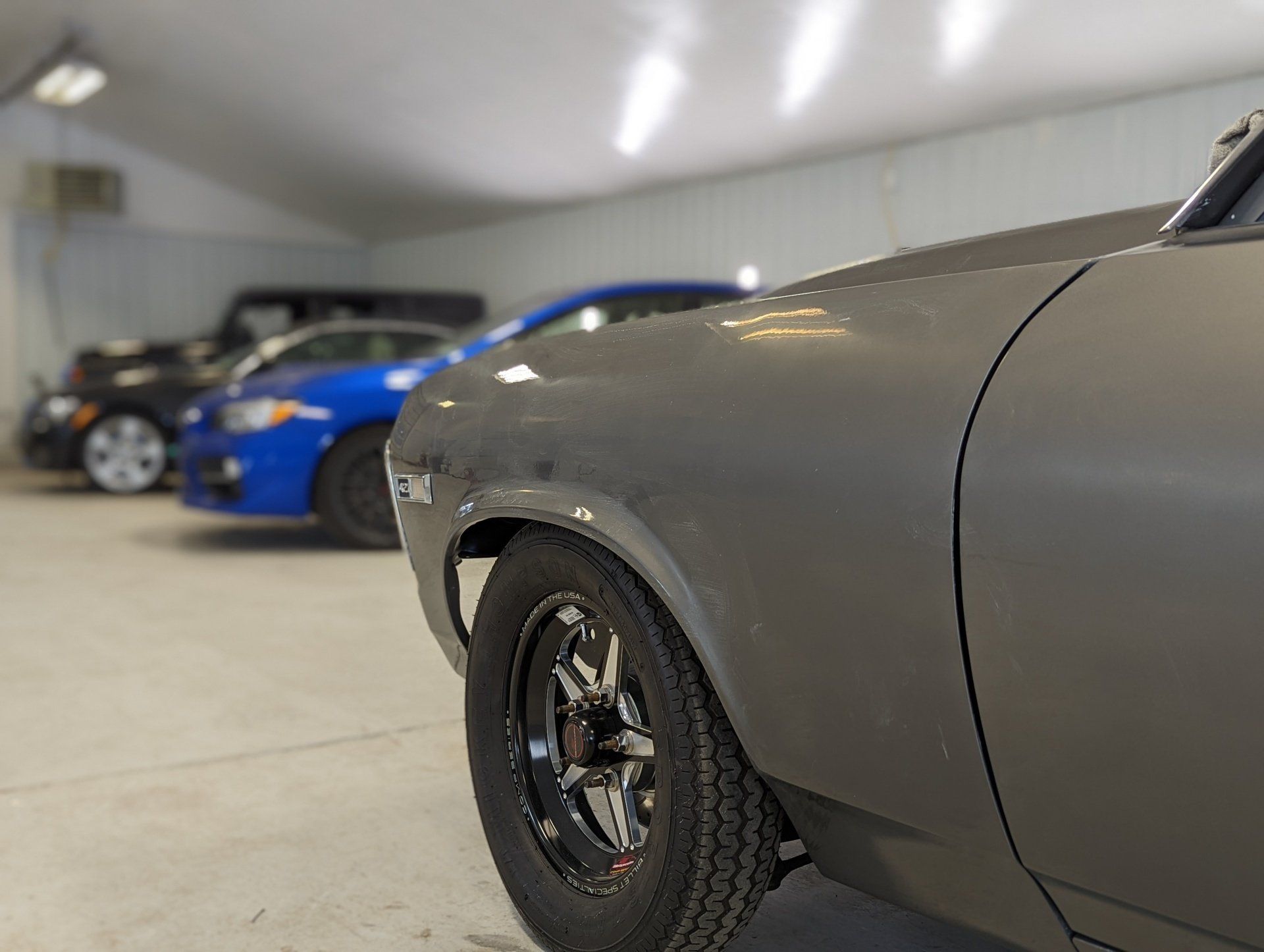 A row of cars are parked in a garage.