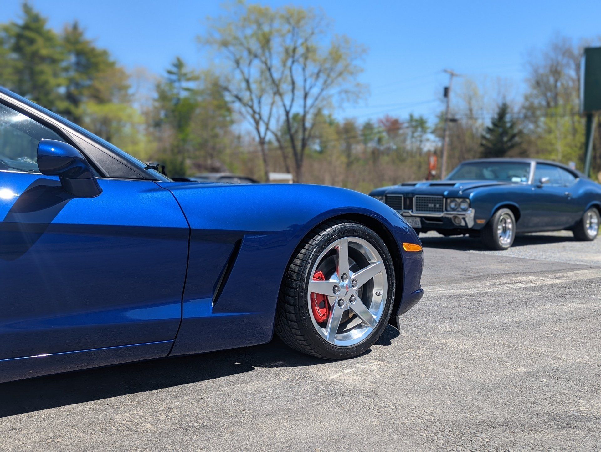 Two blue sports cars are parked next to each other in a parking lot.