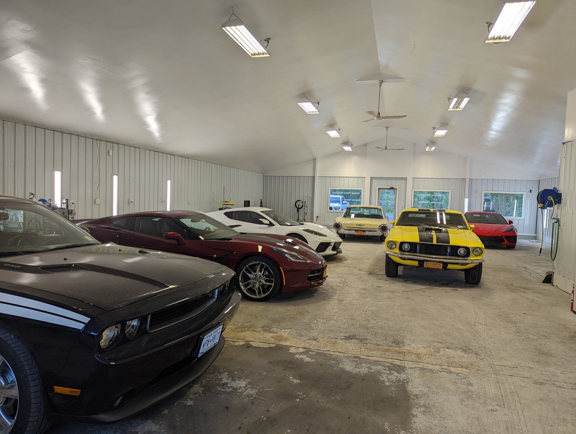 A row of cars are parked in a garage.