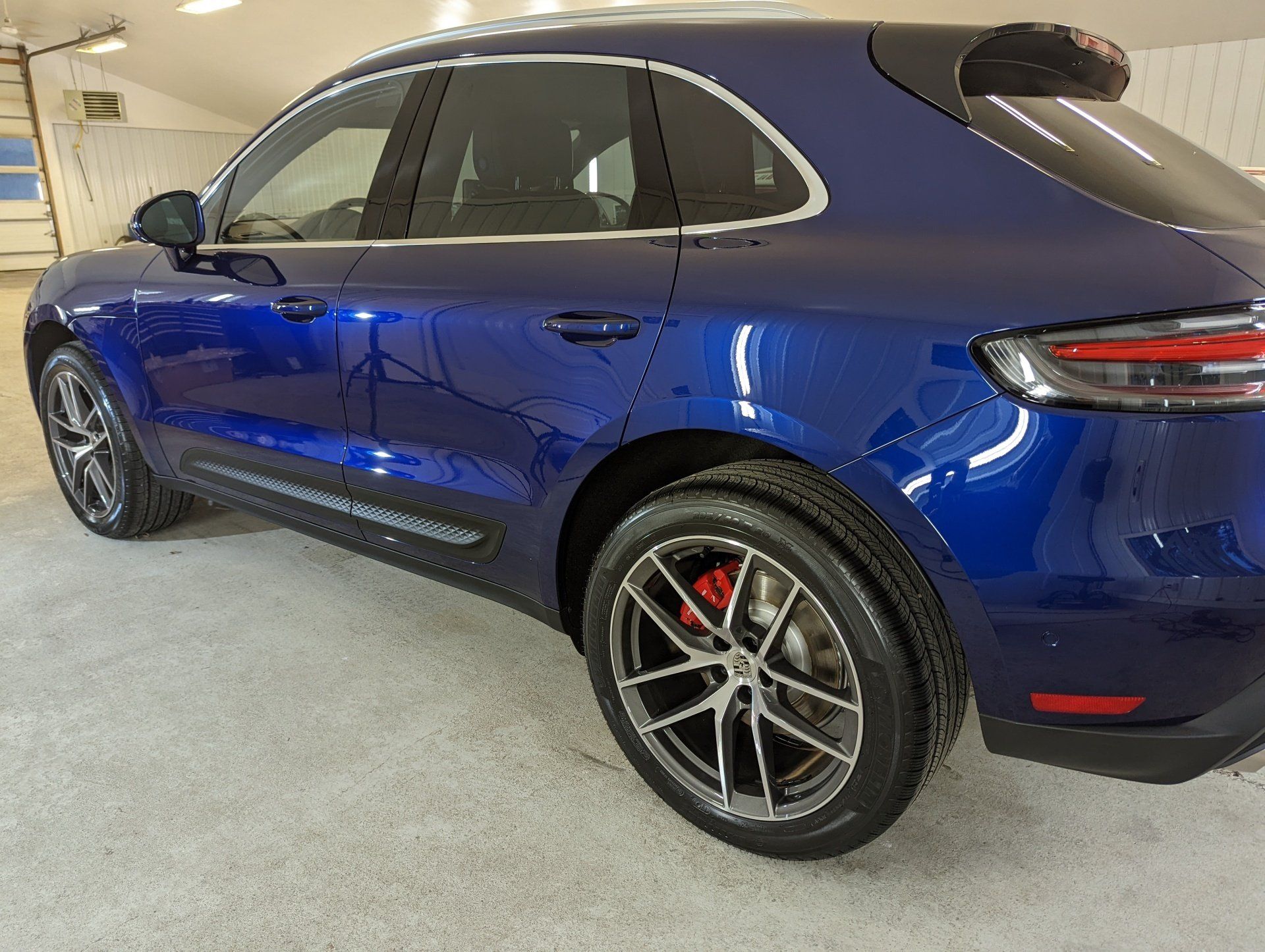 A blue porsche macan turbo is parked in a garage.