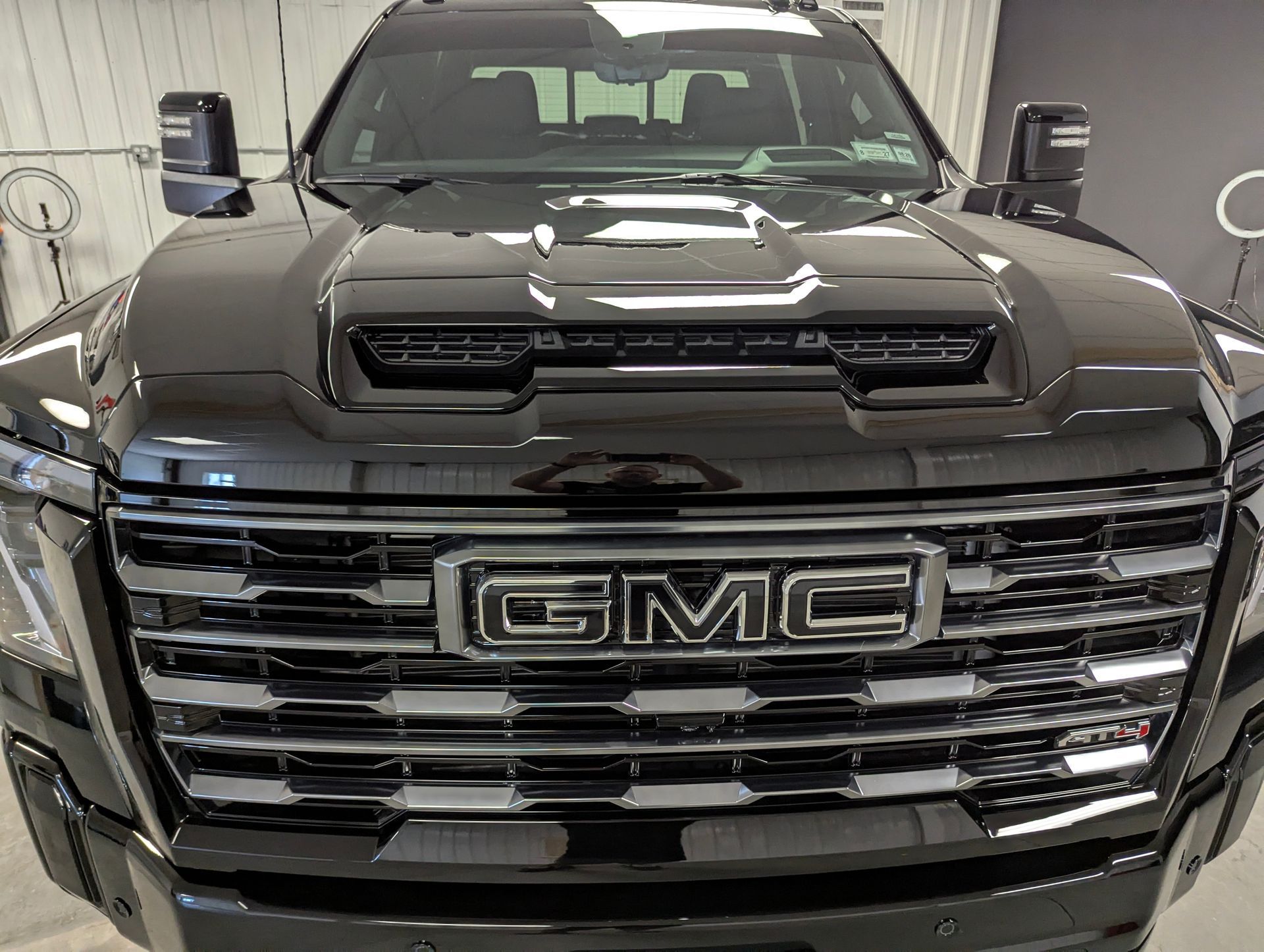 Black GMC truck front view with large chrome grille and GMC emblem.