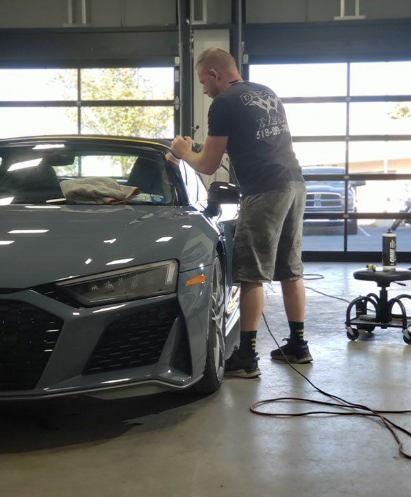 A man in a black shirt is working on a car