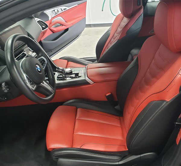 The inside of a car with red seats and black seats
