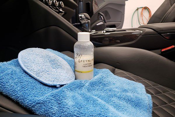 A car seat with a blue towel and a bottle on it