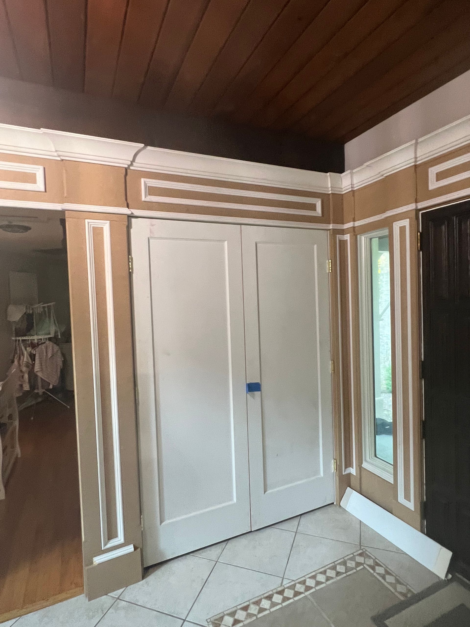 A room with two white doors and a wooden ceiling