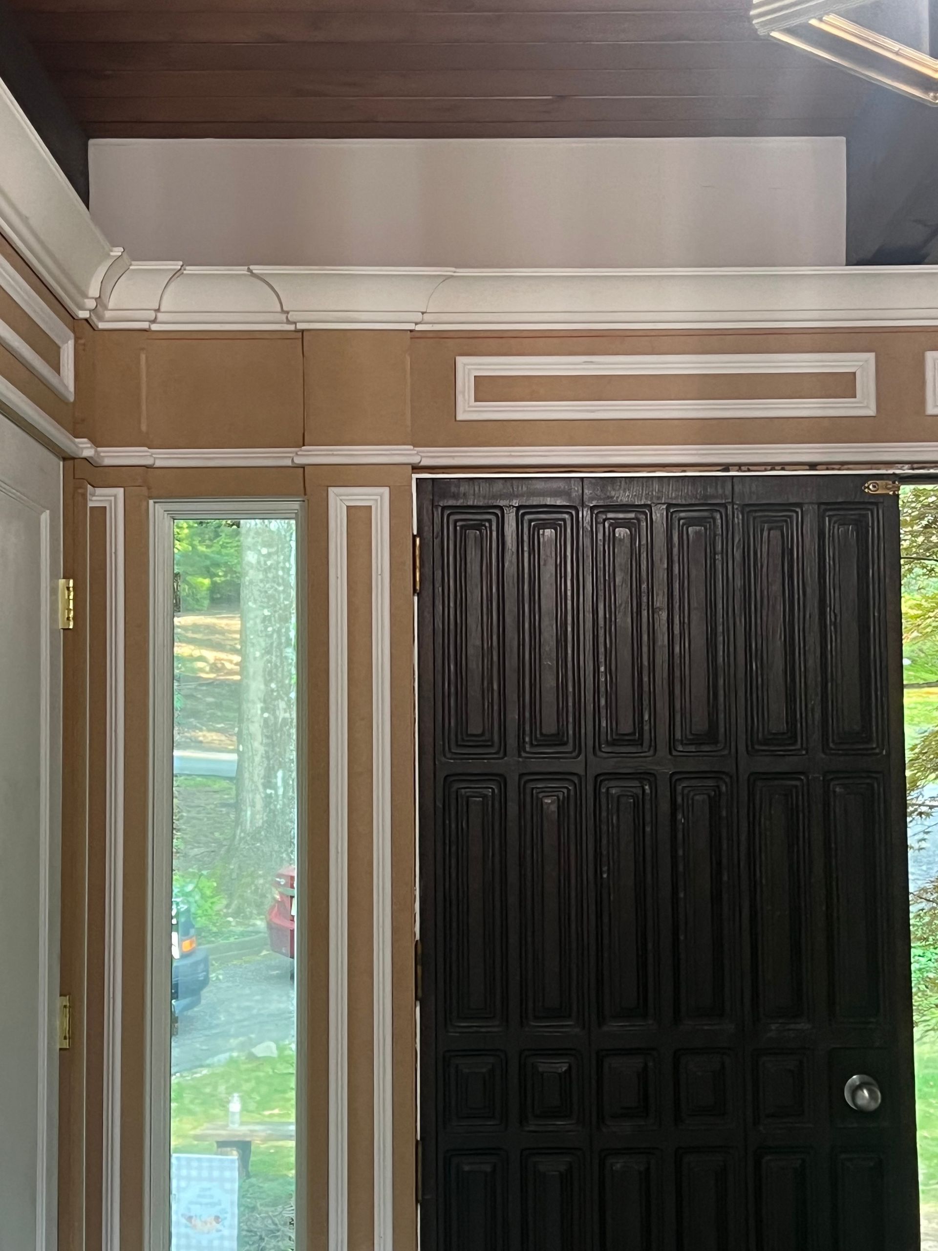 A black door is open in a room with a ceiling fan.