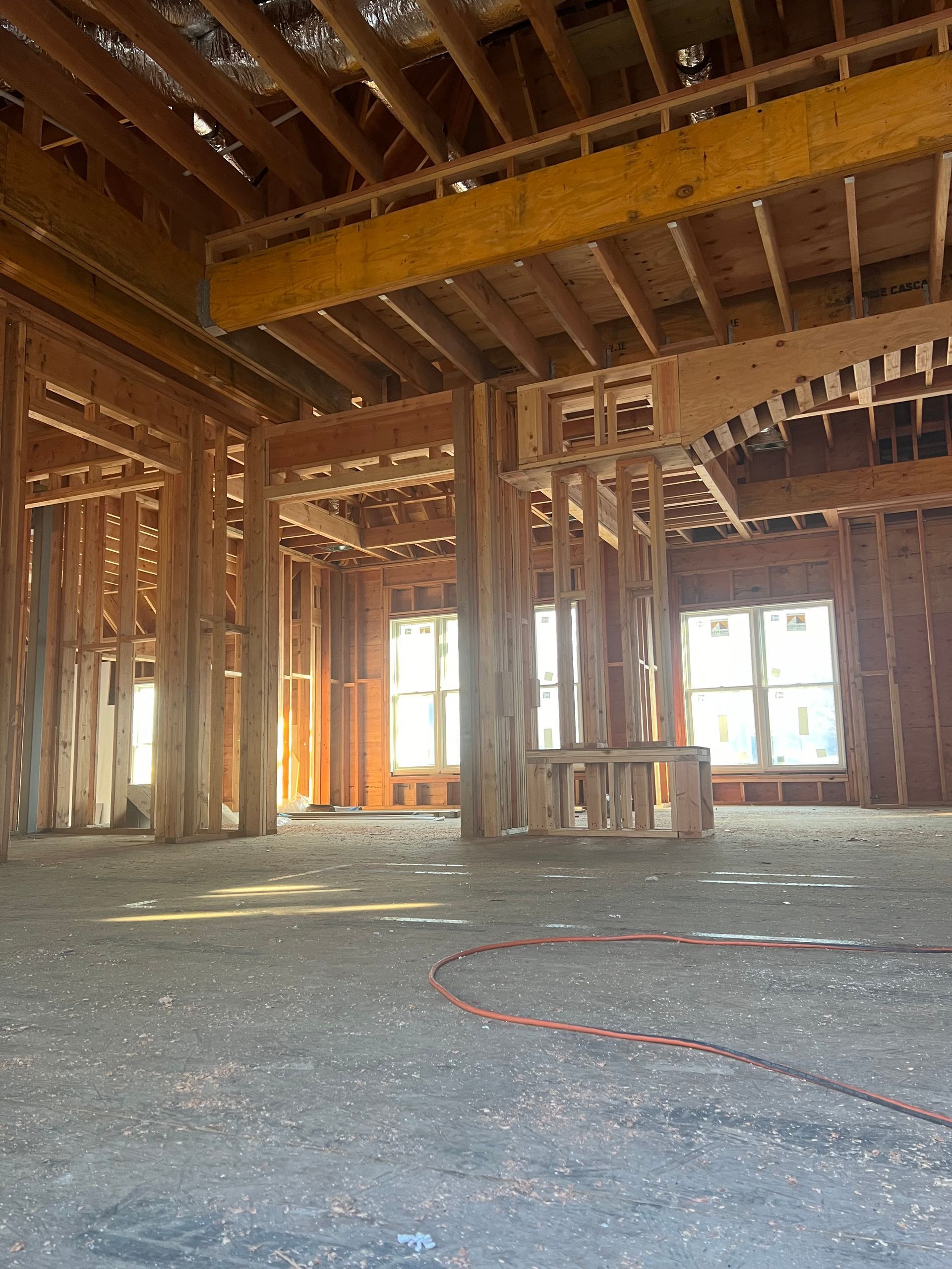 An empty room with a lot of wooden beams and windows.