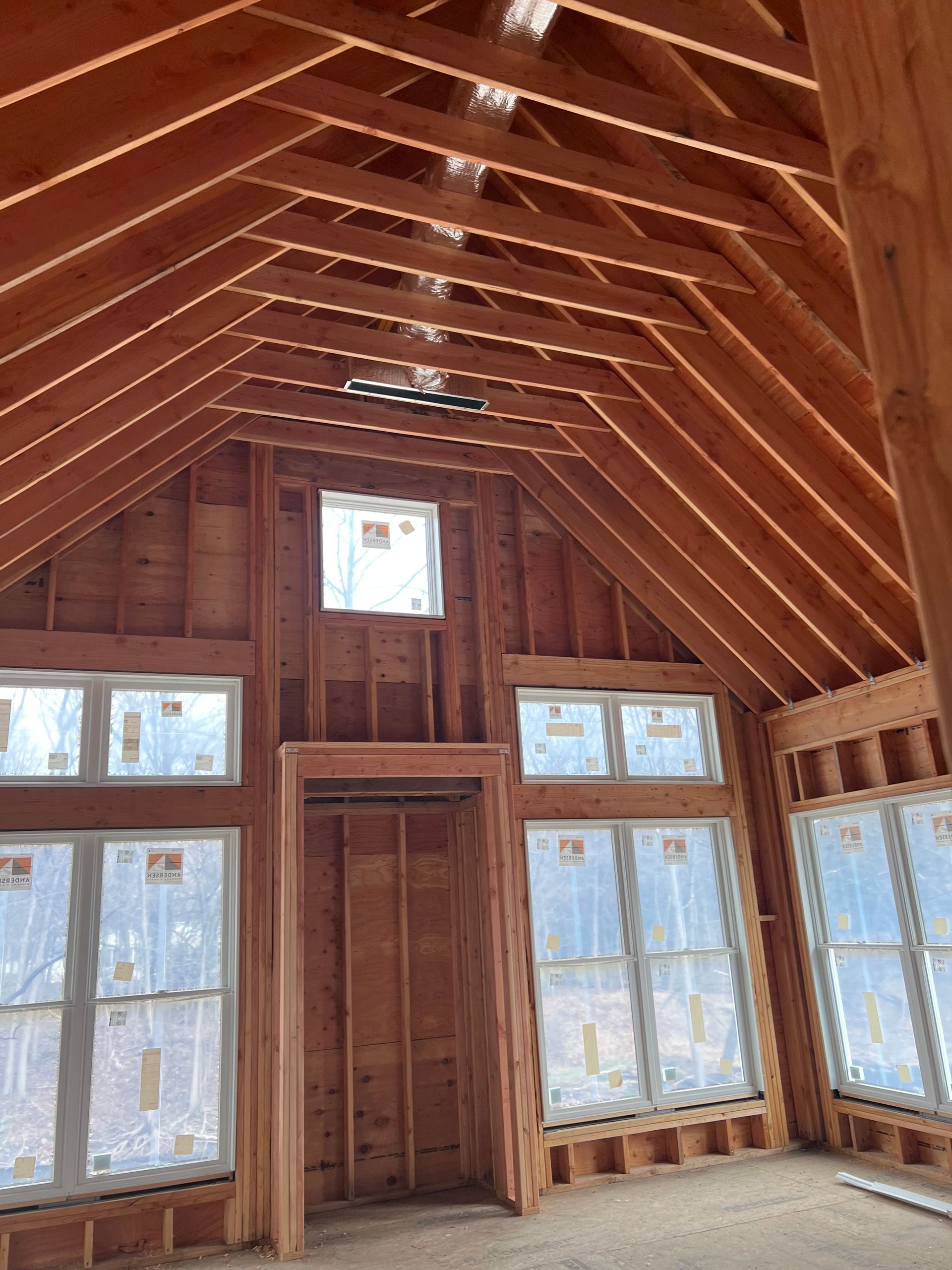 A room with a lot of windows and a wooden ceiling.