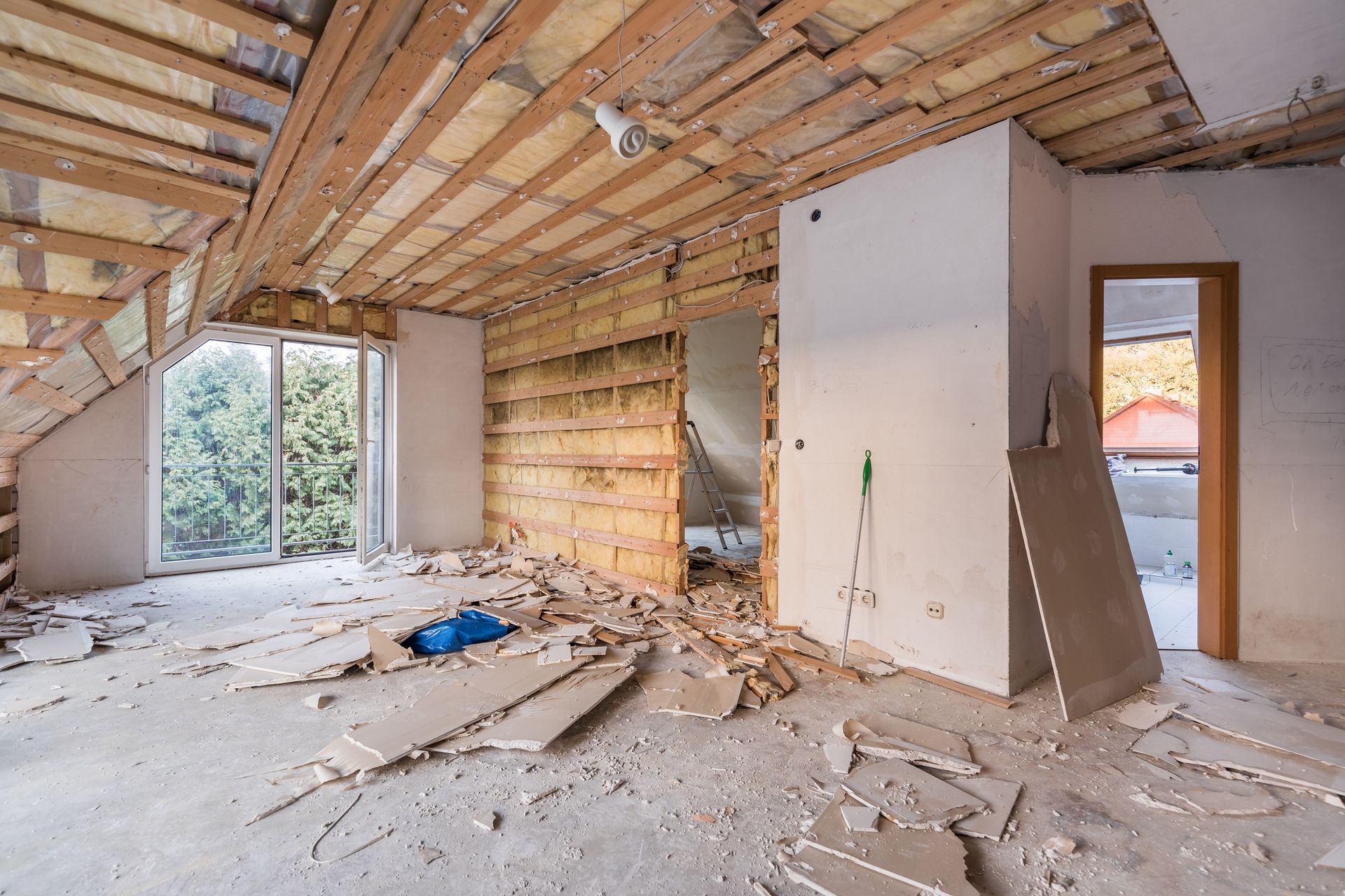 An empty room with a wooden ceiling and a door.