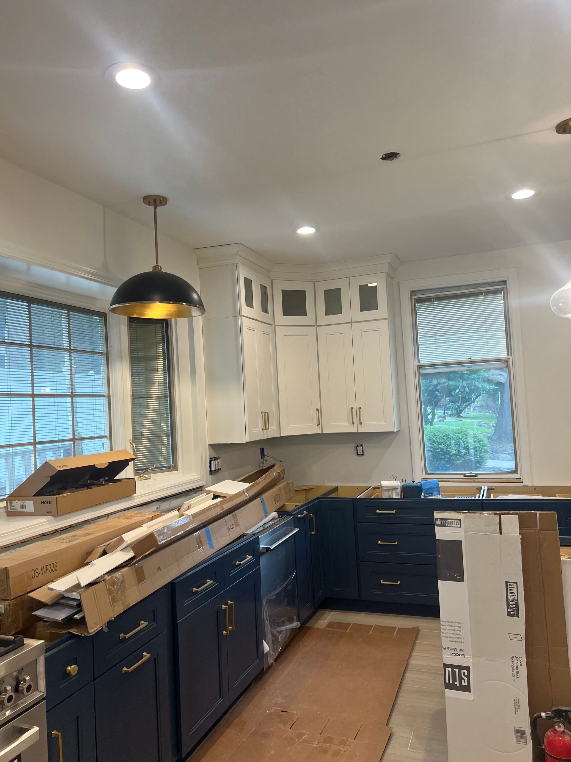 A kitchen with blue cabinets and white cabinets is being remodeled.
