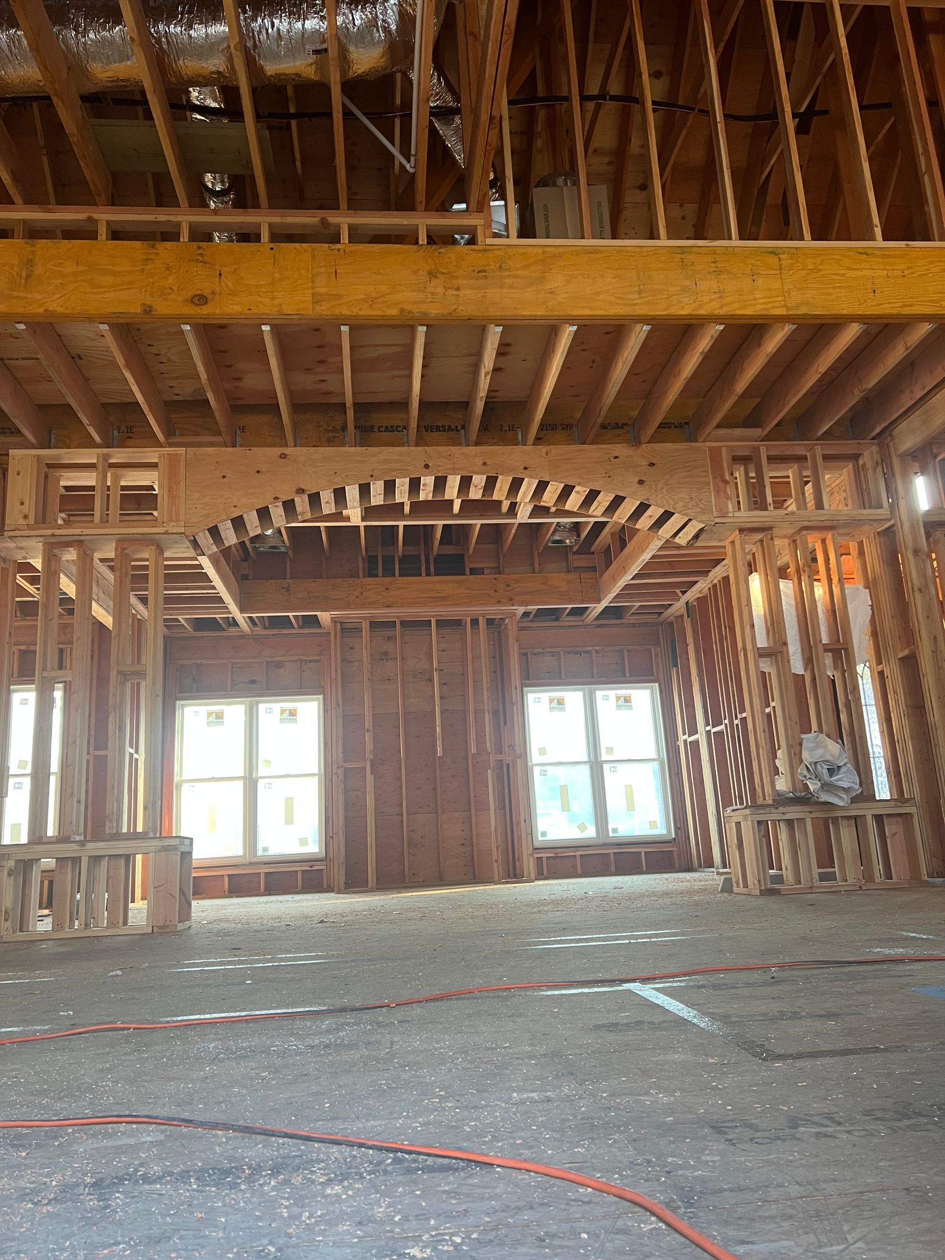 The inside of a building under construction with a lot of wooden beams.