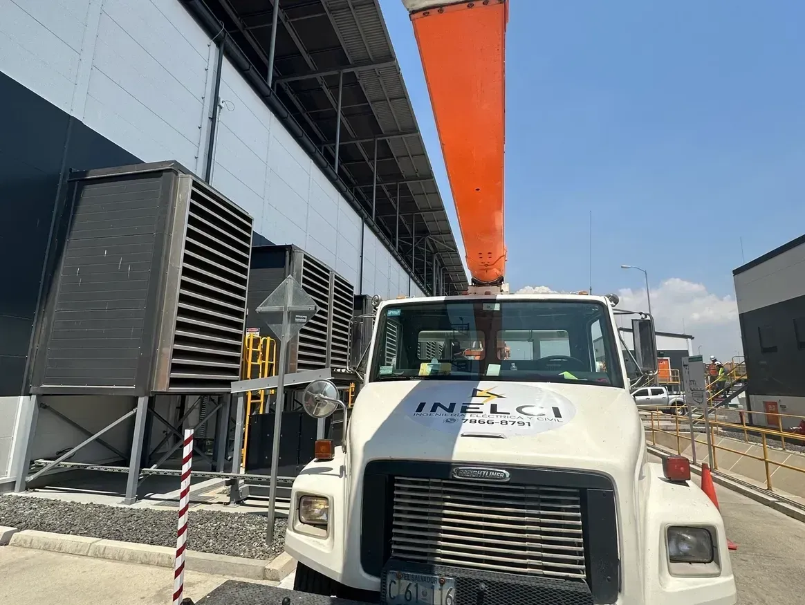 Vista desde un ángulo elevado de una escalera de caracol con barandillas de madera oscura y escalones grises, ubicada en un interior luminoso y moderno.