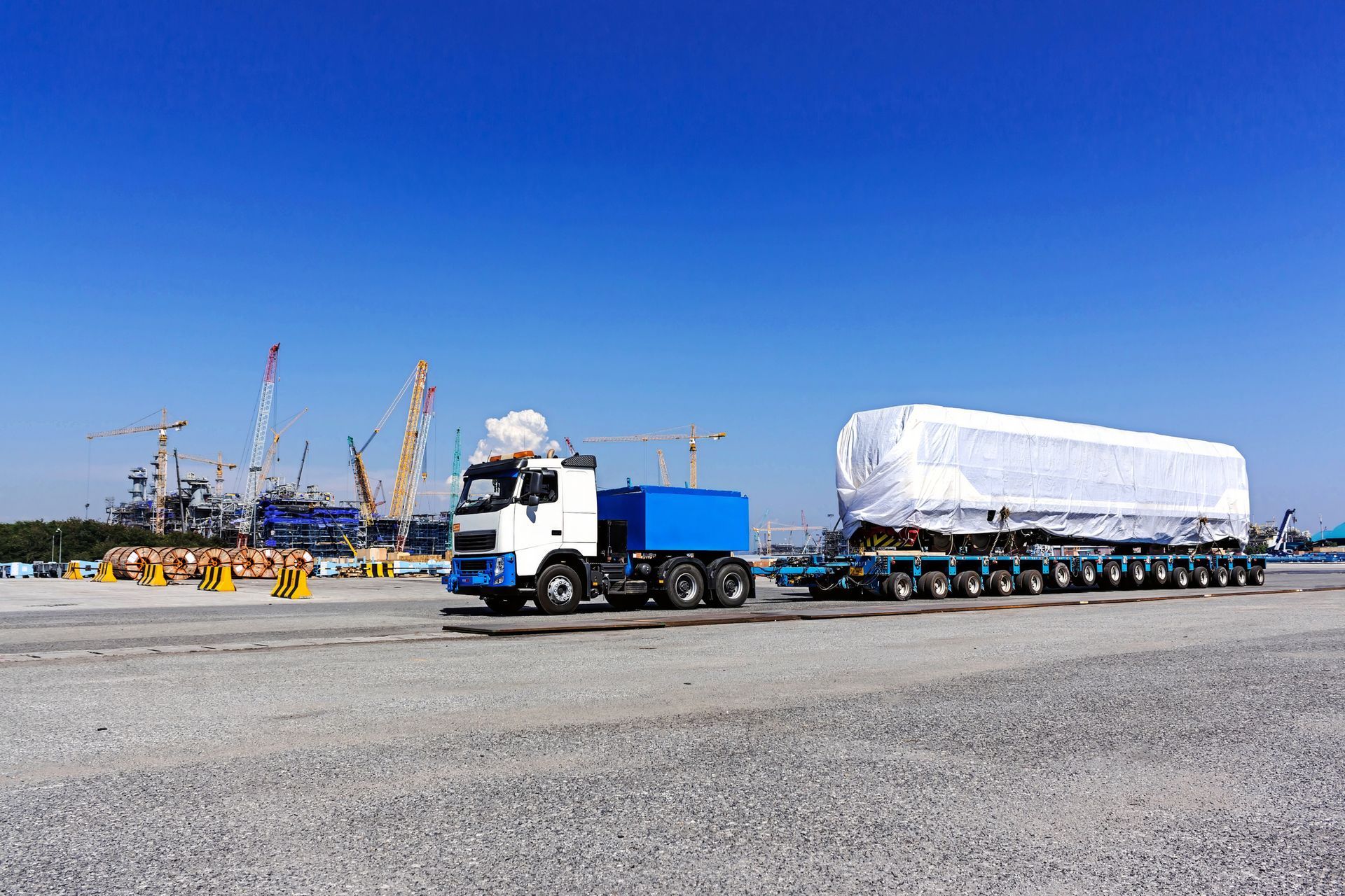 Covered cargo truck at industrial yard with crane in background. Covered cargo truck at industrial yard with crane in background.