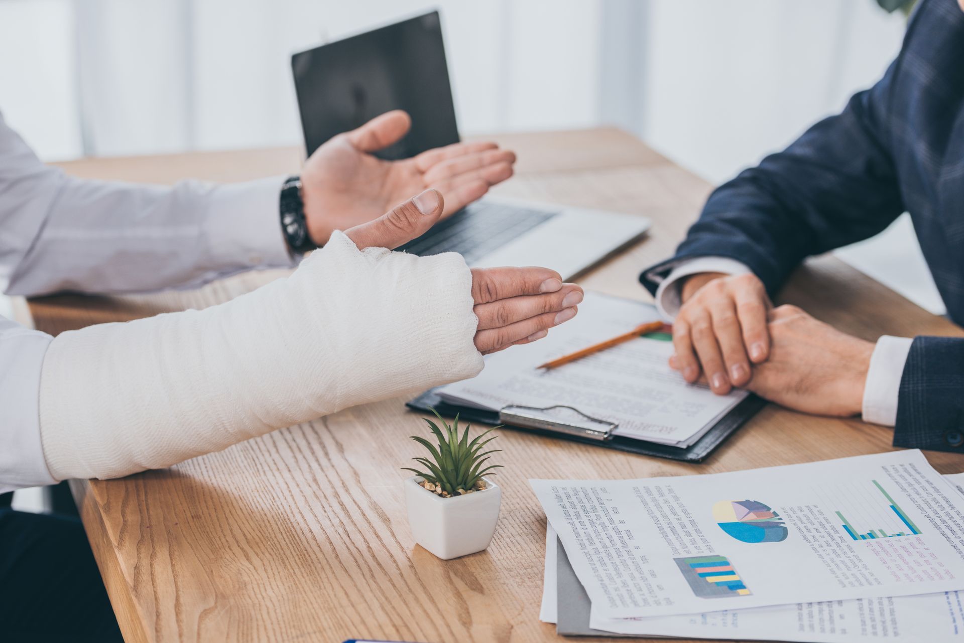A man with a cast on his arm is holding the hand of another man.