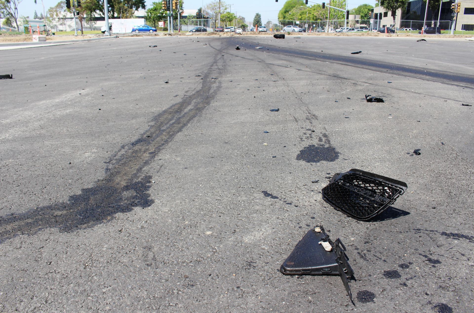 A broken phone is laying on the side of the road