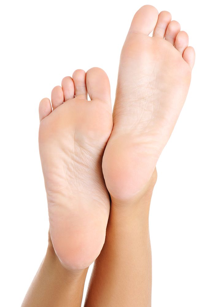 Two feet, soles up, angled toward the viewer; light skin, isolated on white background.