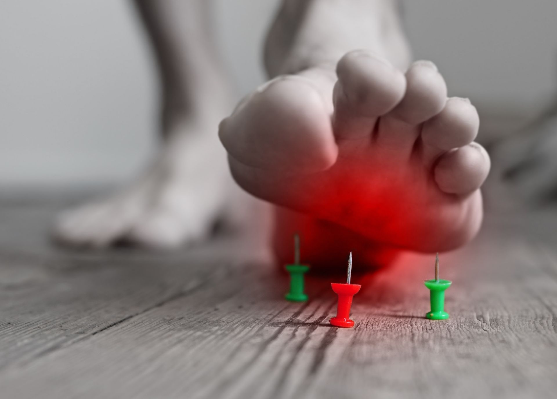Foot stepping toward pins, with pain indicated by red highlighting.