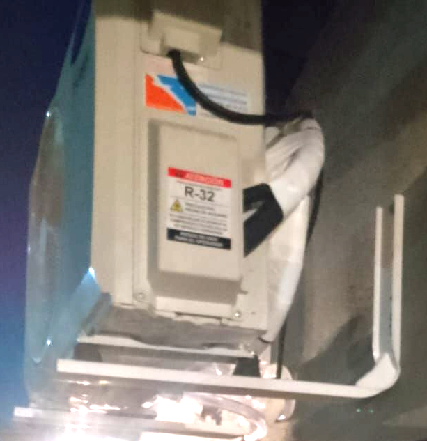 La unidad de aire acondicionado abierta muestra cableado y componentes eléctricos quemados.